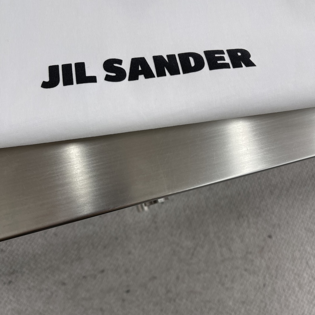 

-2025 Jil Sander 品牌经典黑白小字母T恤。
以其极简主义的设计理念，诠释了低调的奢华