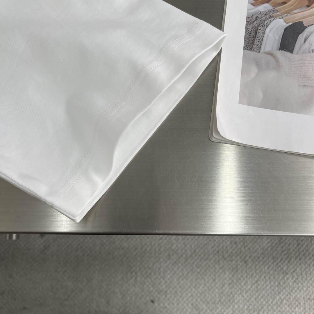 

-2025 Jil Sander 品牌经典黑白小字母T恤。
以其极简主义的设计理念，诠释了低调的奢华