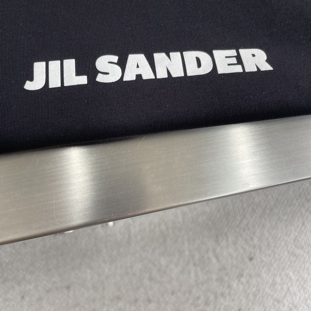 

-2025 Jil Sander 品牌经典黑白小字母T恤。
以其极简主义的设计理念，诠释了低调的奢华