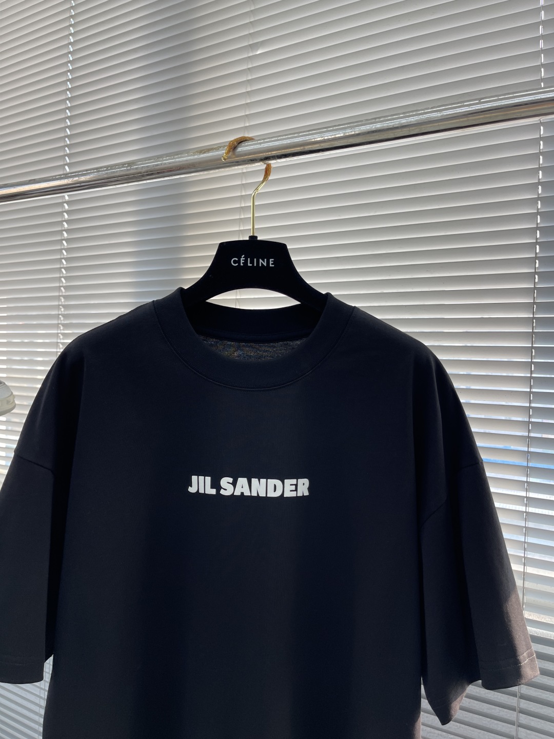 

-2025 Jil Sander 品牌经典黑白小字母T恤。
以其极简主义的设计理念，诠释了低调的奢华