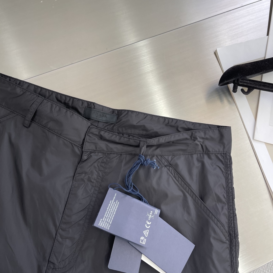 

-PRAD  25SS新款金属微标再生尼龙长裤
这款采用尼龙面料制作而成，门禁带隐藏钩的拉链闭合，前