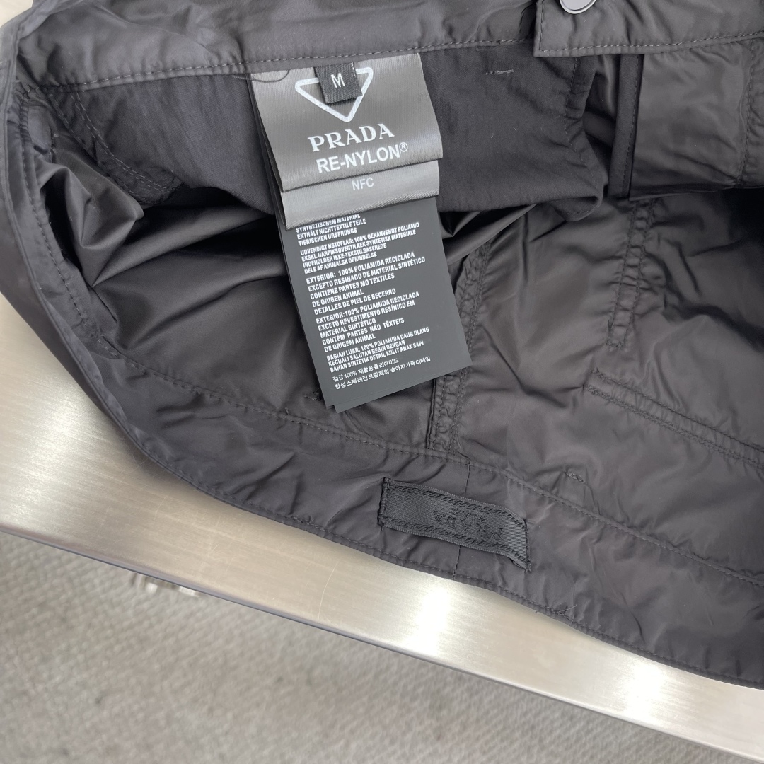 

-PRAD  25SS新款金属微标再生尼龙长裤
这款采用尼龙面料制作而成，门禁带隐藏钩的拉链闭合，前