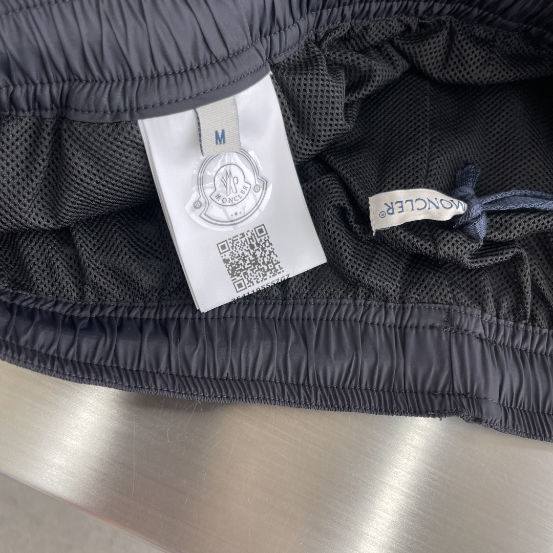 -mon 织带式短裤，这款短裤采用再生面料制作而成，侧口袋饰有红蓝式经典织带，松紧腰头搭配有橡筋抽绳，金