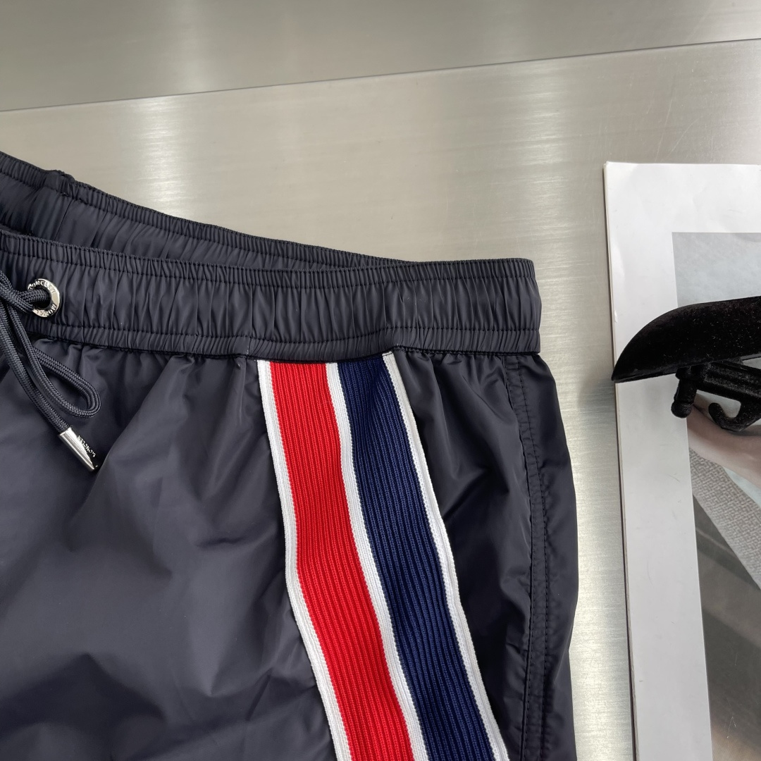 -mon 织带式短裤，这款短裤采用再生面料制作而成，侧口袋饰有红蓝式经典织带，松紧腰头搭配有橡筋抽绳，金