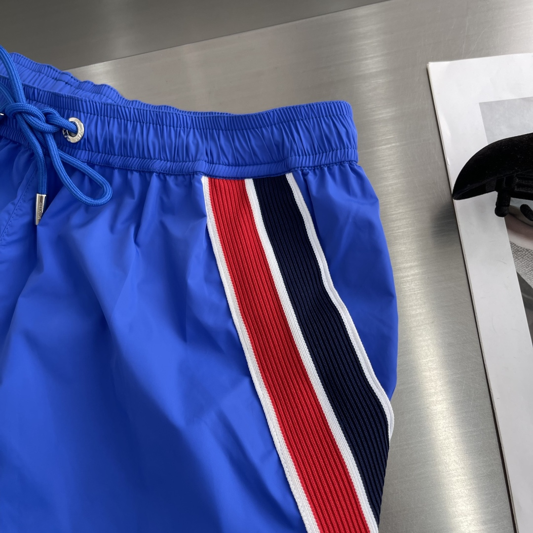 -mon 织带式短裤，这款短裤采用再生面料制作而成，侧口袋饰有红蓝式经典织带，松紧腰头搭配有橡筋抽绳，金