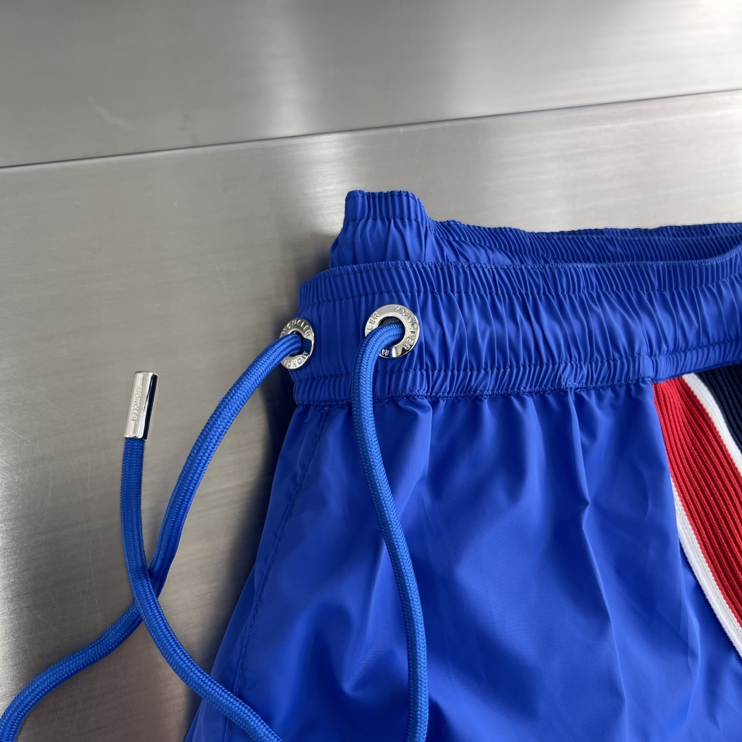 -mon 织带式短裤，这款短裤采用再生面料制作而成，侧口袋饰有红蓝式经典织带，松紧腰头搭配有橡筋抽绳，金