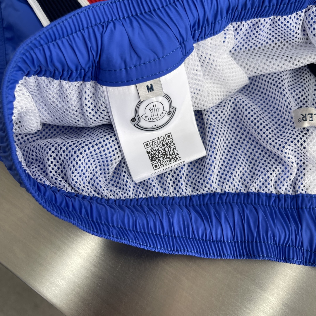 -mon 织带式短裤，这款短裤采用再生面料制作而成，侧口袋饰有红蓝式经典织带，松紧腰头搭配有橡筋抽绳，金