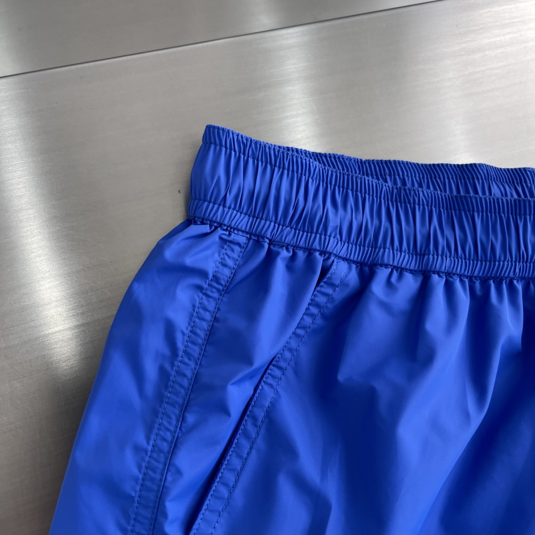 -mon 织带式短裤，这款短裤采用再生面料制作而成，侧口袋饰有红蓝式经典织带，松紧腰头搭配有橡筋抽绳，金