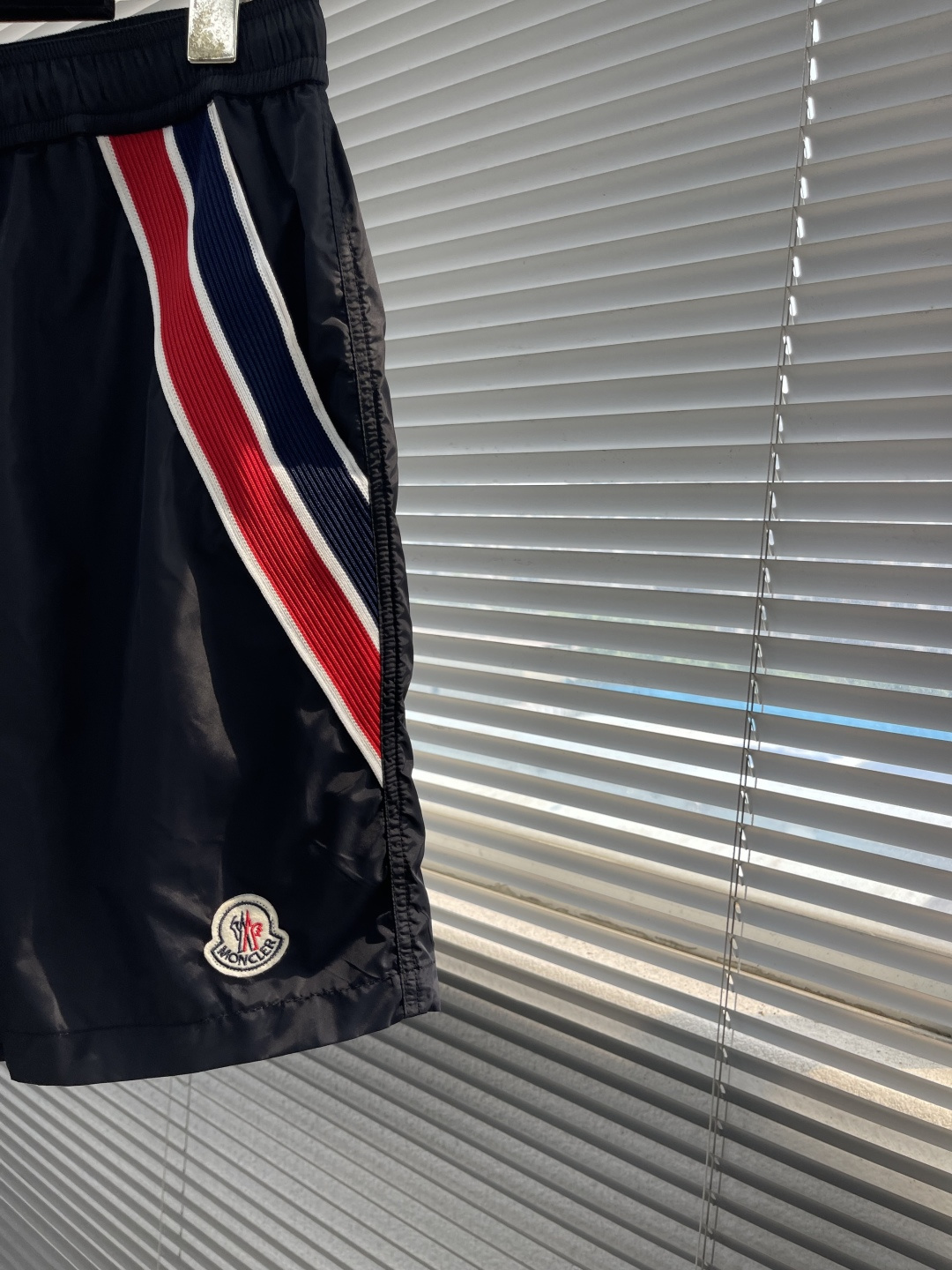 -mon 织带式短裤，这款短裤采用再生面料制作而成，侧口袋饰有红蓝式经典织带，松紧腰头搭配有橡筋抽绳，金