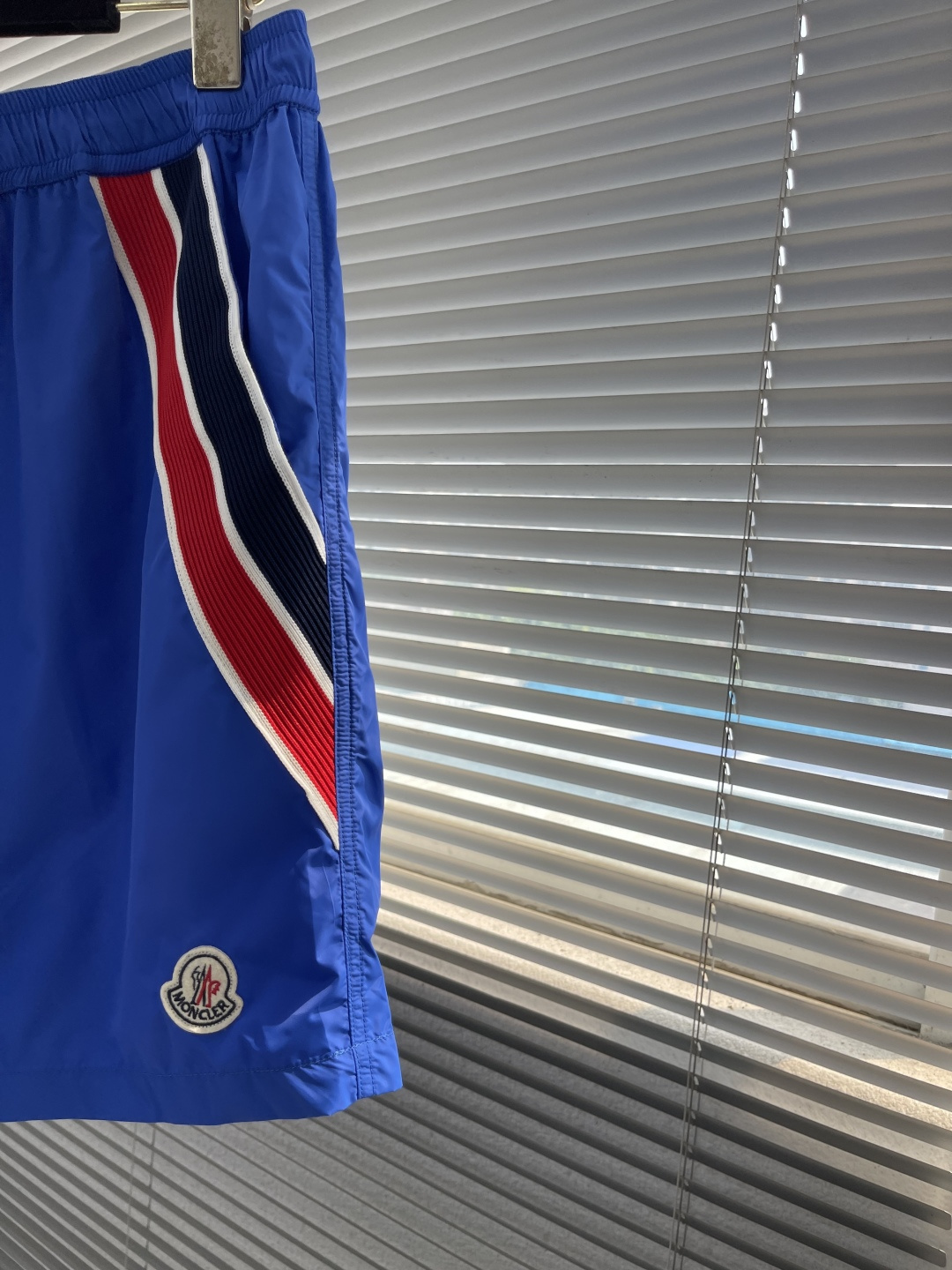 -mon 织带式短裤，这款短裤采用再生面料制作而成，侧口袋饰有红蓝式经典织带，松紧腰头搭配有橡筋抽绳，金