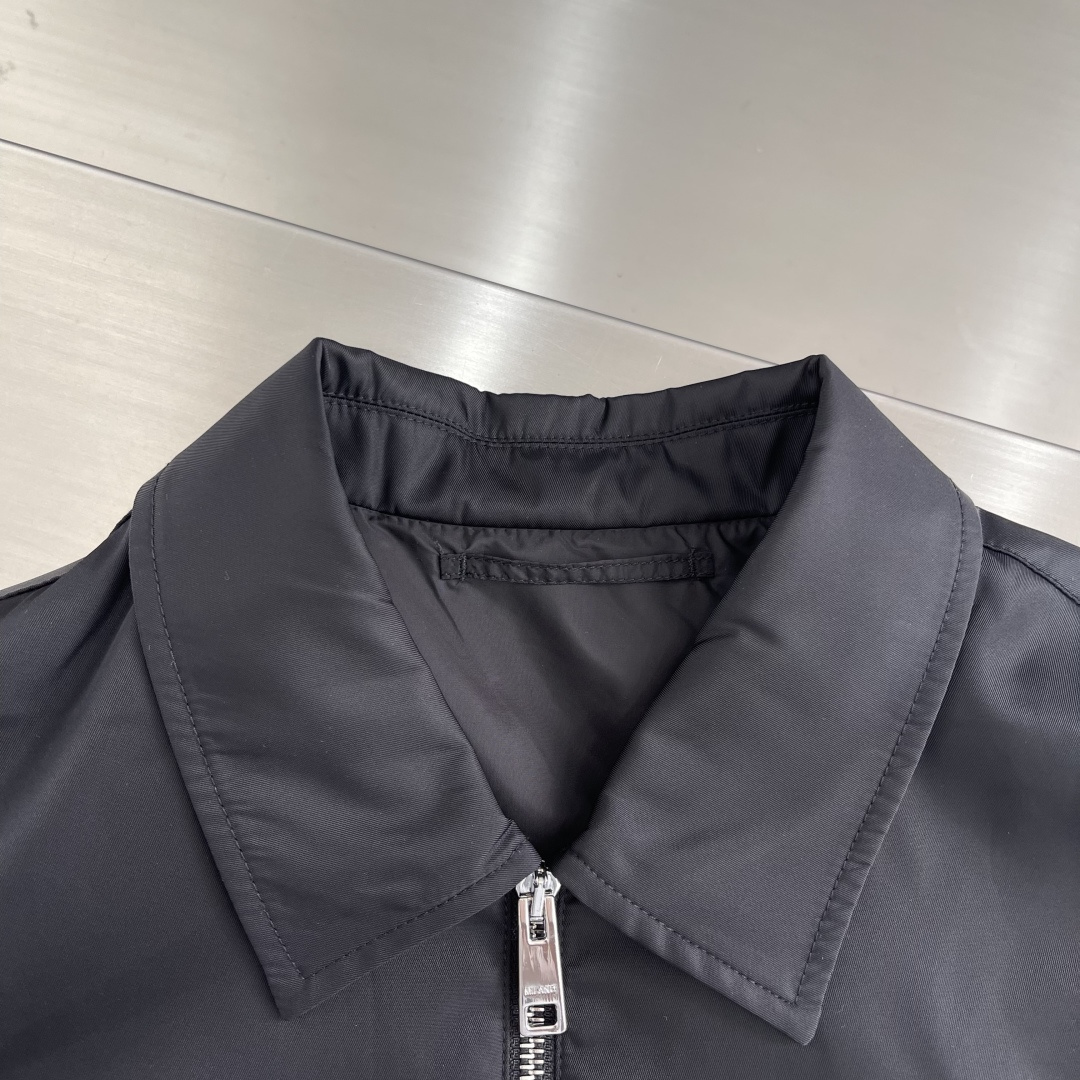 -PRAD 再生尼龙翻领外套选用品牌标志性的再生尼龙面料，与传统尼龙性能相当，具备高强度，抗撕裂，耐磨损