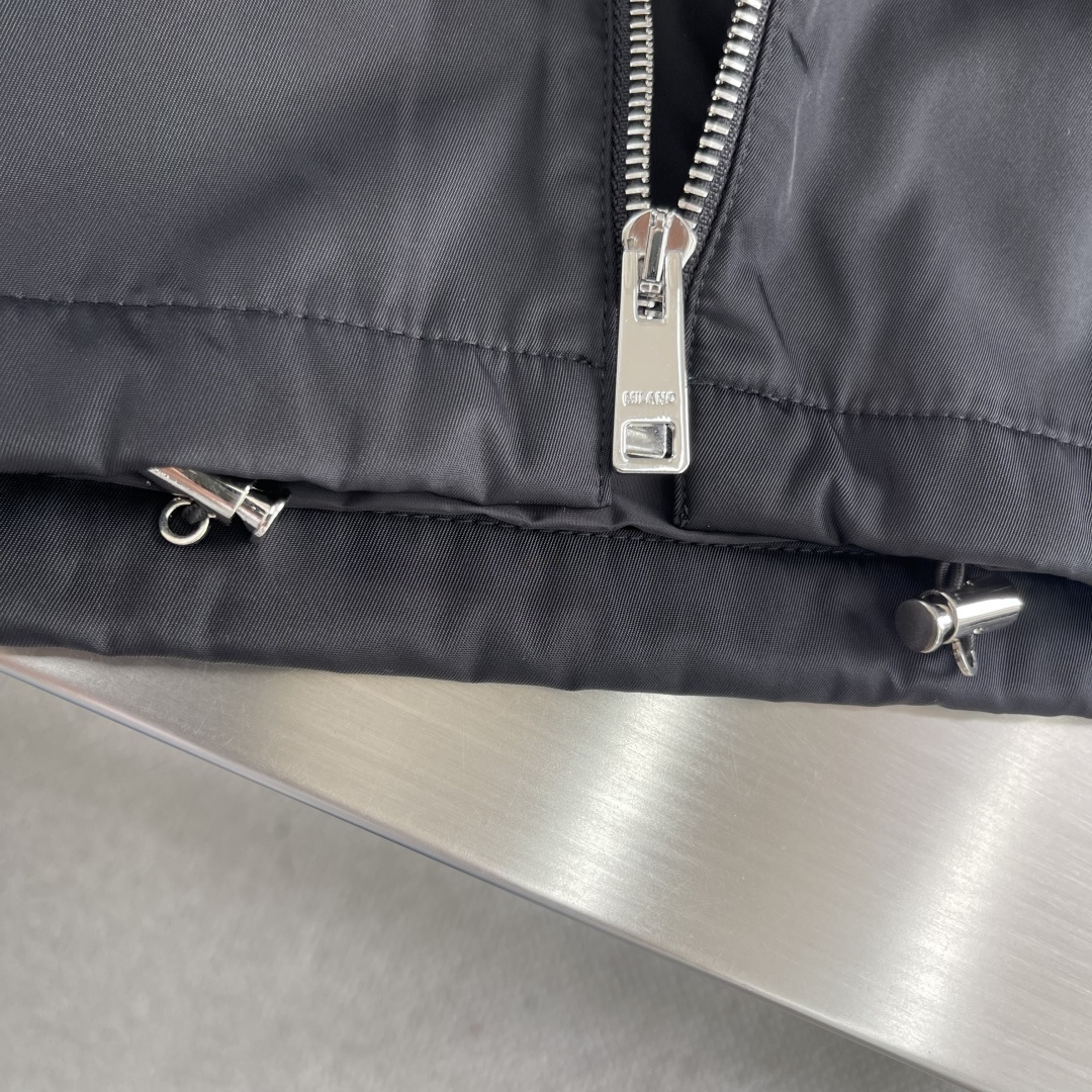 -PRAD 再生尼龙翻领外套选用品牌标志性的再生尼龙面料，与传统尼龙性能相当，具备高强度，抗撕裂，耐磨损