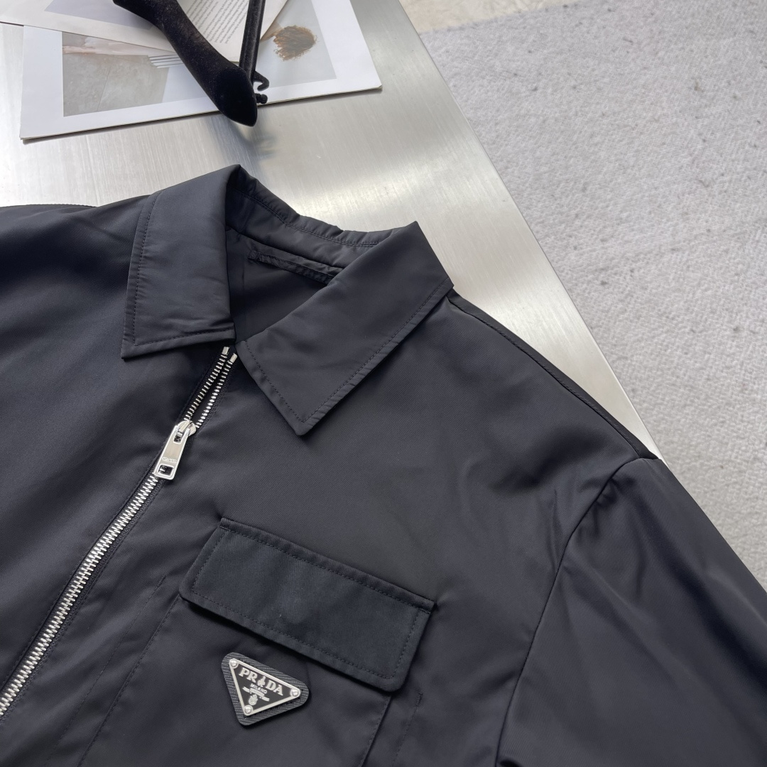 -PRAD 再生尼龙翻领外套选用品牌标志性的再生尼龙面料，与传统尼龙性能相当，具备高强度，抗撕裂，耐磨损