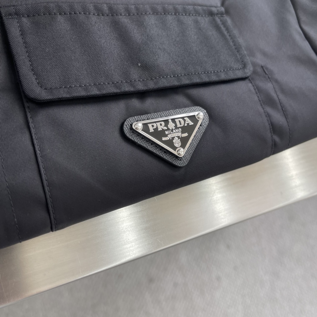 -PRAD 再生尼龙翻领外套选用品牌标志性的再生尼龙面料，与传统尼龙性能相当，具备高强度，抗撕裂，耐磨损