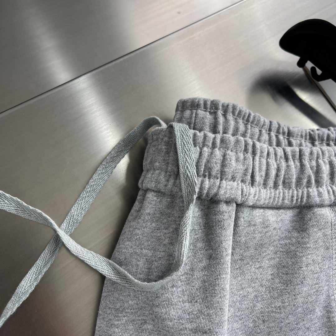 -PRAD 烧花三角标识卫裤采用380克双股鱼鳞毛圈面料，该款原版定染深花灰，搭配480克双纱同缸定染螺