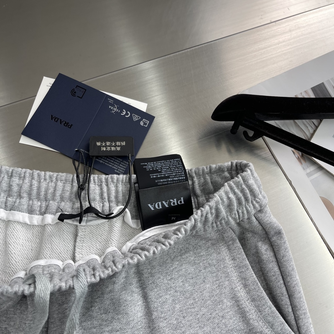 -PRAD 烧花三角标识卫裤采用380克双股鱼鳞毛圈面料，该款原版定染深花灰，搭配480克双纱同缸定染螺
