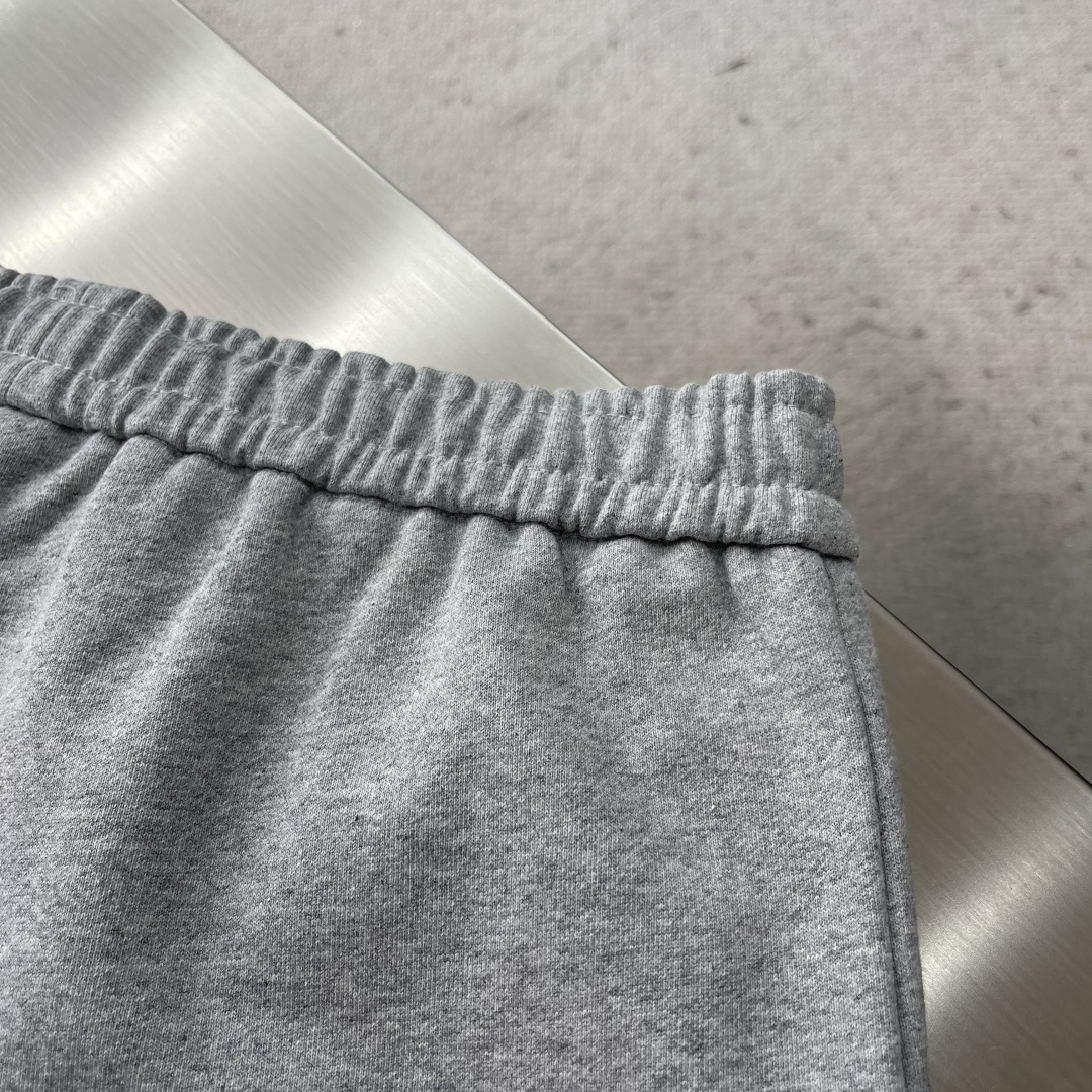 -PRAD 烧花三角标识卫裤采用380克双股鱼鳞毛圈面料，该款原版定染深花灰，搭配480克双纱同缸定染螺