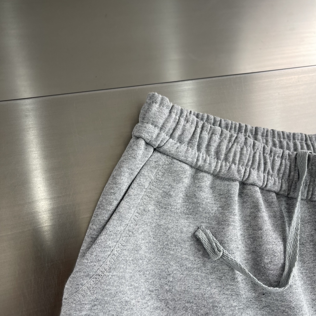 -PRAD 烧花三角标识卫裤采用380克双股鱼鳞毛圈面料，该款原版定染深花灰，搭配480克双纱同缸定染螺