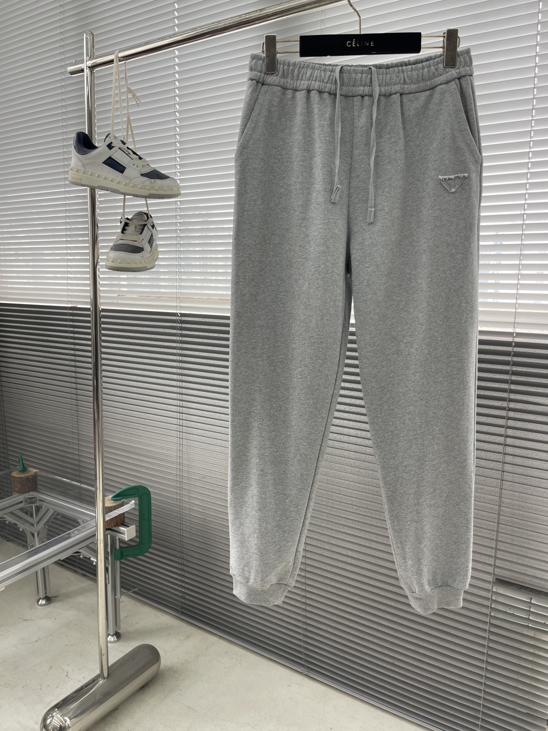 -PRAD 烧花三角标识卫裤采用380克双股鱼鳞毛圈面料，该款原版定染深花灰，搭配480克双纱同缸定染螺