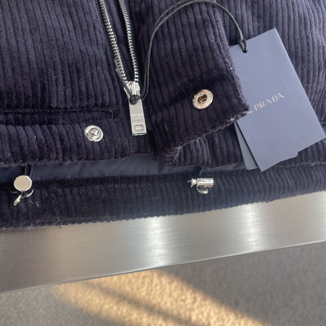 -PRAD 25FW 灯芯绒羽绒马甲这款短裁灯芯绒羽绒马甲 蕴藉Prad的混搭个性 金属三角形徽标展现标