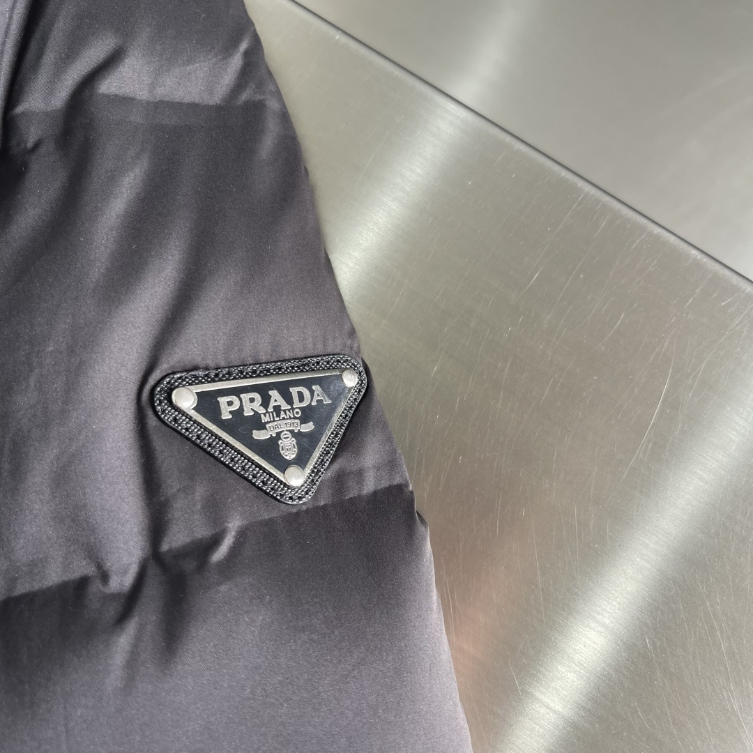 -PRAD 25年冬季新款羽绒服经典立领轻薄款，拉链口袋、袖臂三角标点缀，可调节袖口以及按扣拉链翻盖门襟