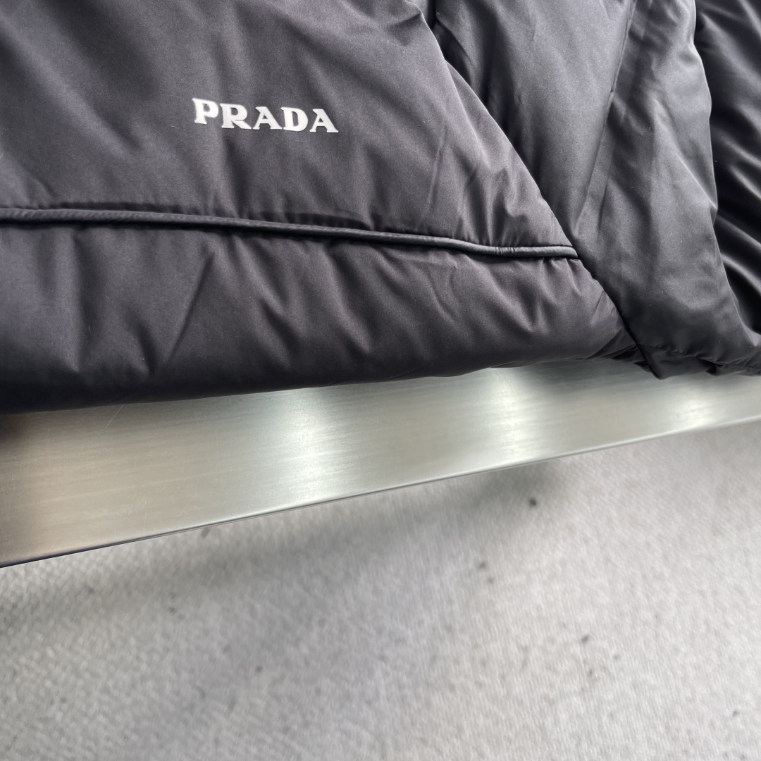 -PRAD 25年冬季新款羽绒服经典立领轻薄款，拉链口袋、袖臂三角标点缀，可调节袖口以及按扣拉链翻盖门襟