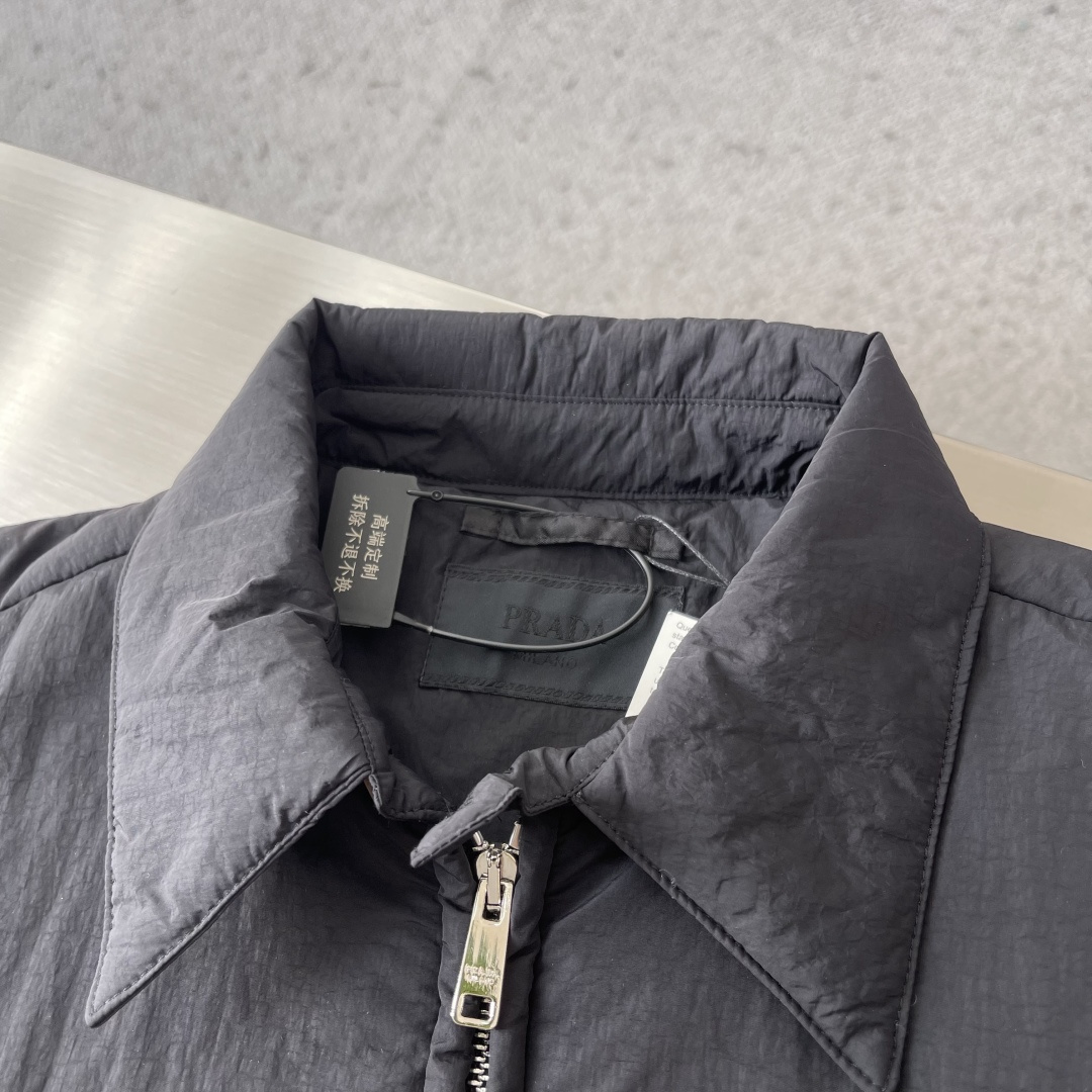 -PRAD 刺绣标识拉链棉服外套采用60支100%磨毛尼料，面料为定织款。刺绣采用3D立体刺绣，小log