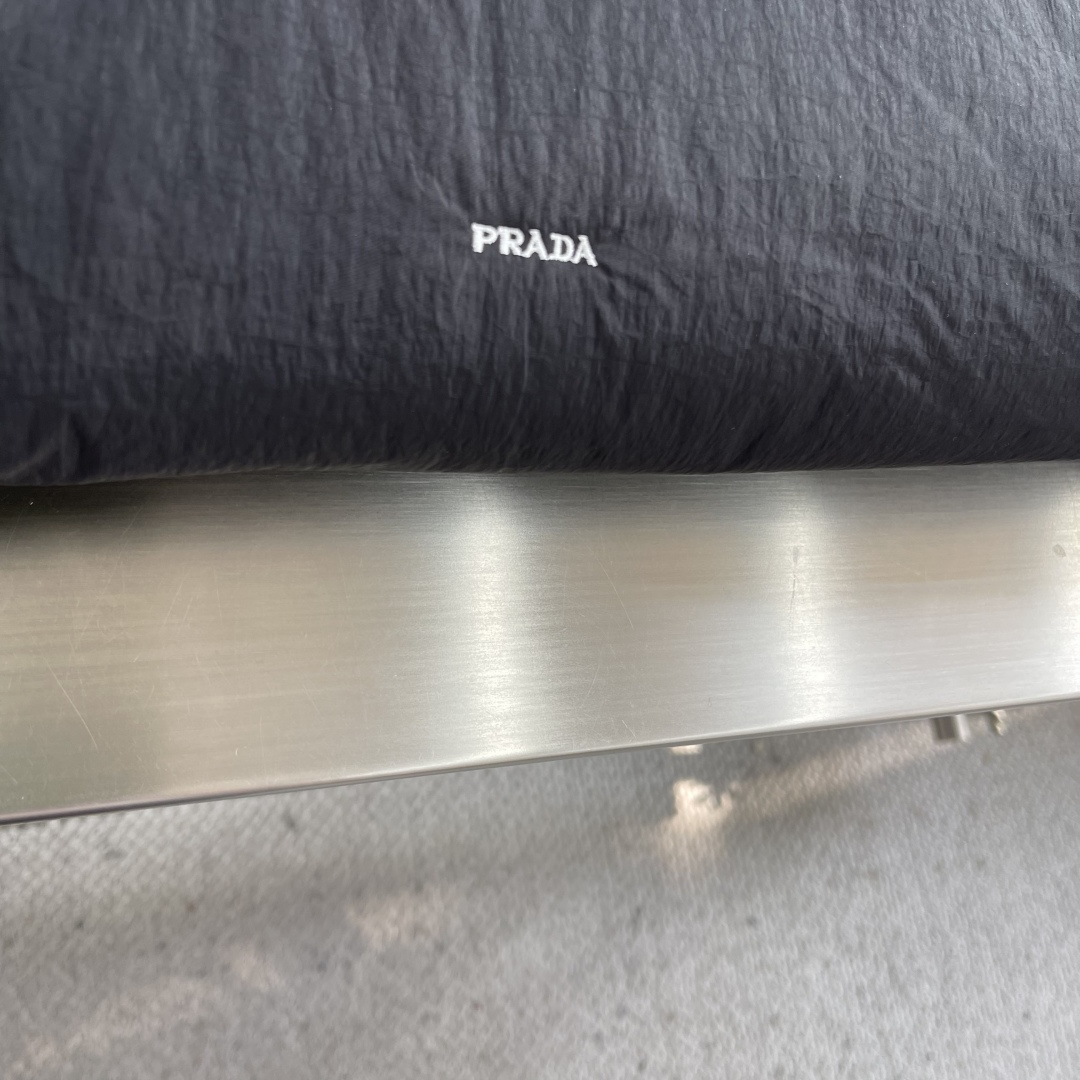 -PRAD 刺绣标识拉链棉服外套采用60支100%磨毛尼料，面料为定织款。刺绣采用3D立体刺绣，小log