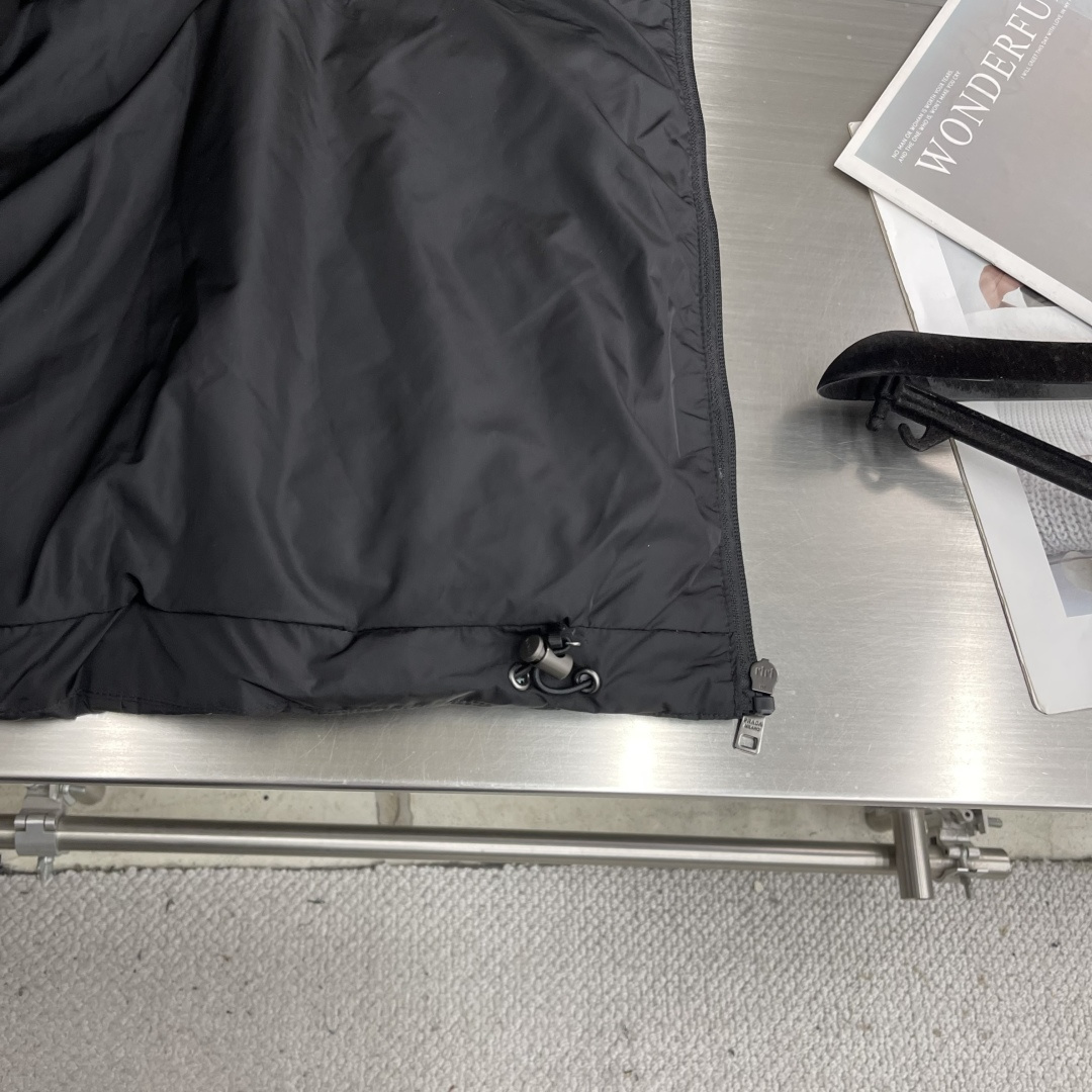 -PRAD 新款三角微标羽绒服。这款羽绒服采用新国标90白鸭绒填充而成，拉链式开合，前胸搭配有三角微标，