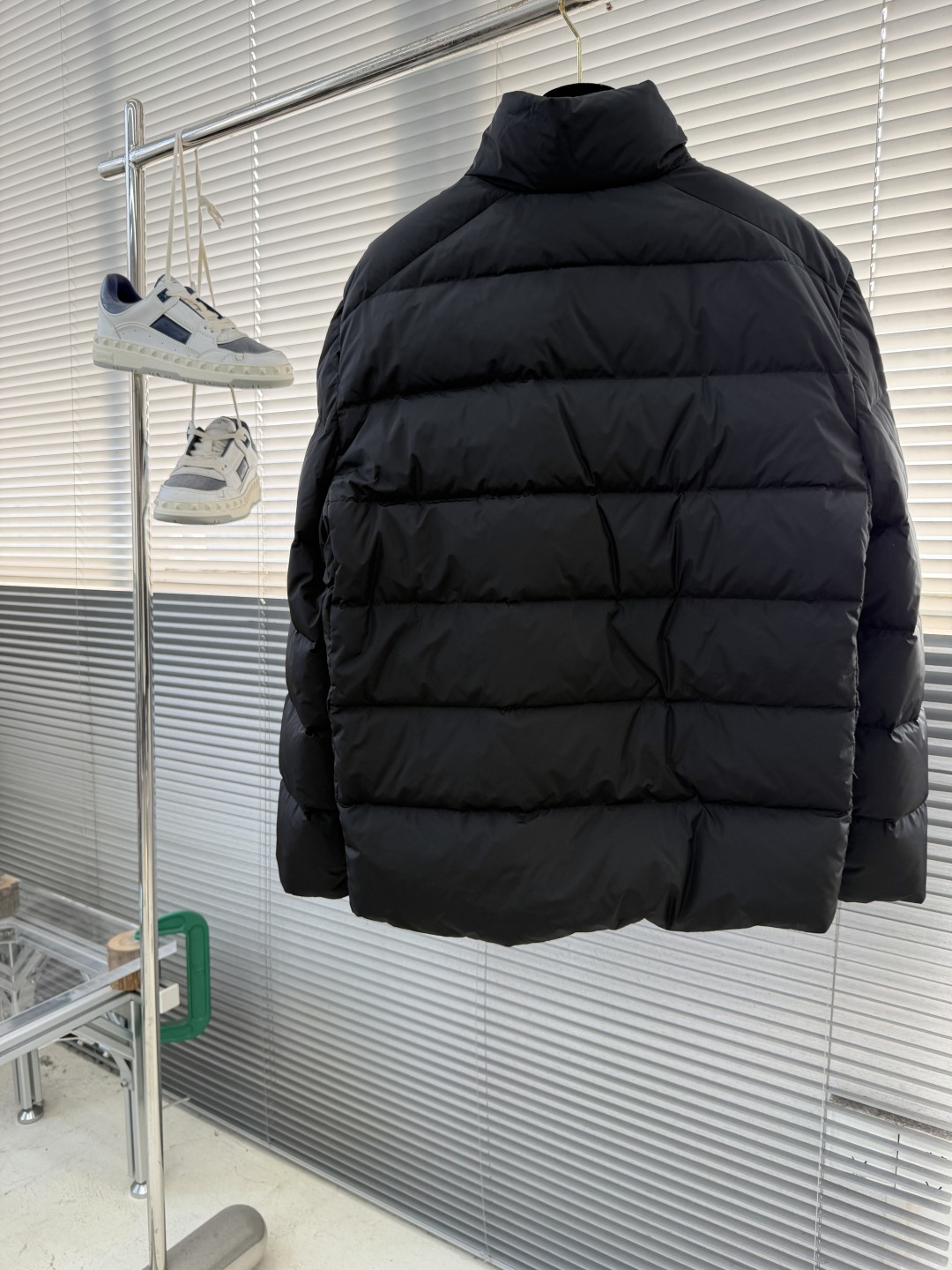 -PRAD 新款三角微标羽绒服。这款羽绒服采用新国标90白鸭绒填充而成，拉链式开合，前胸搭配有三角微标，