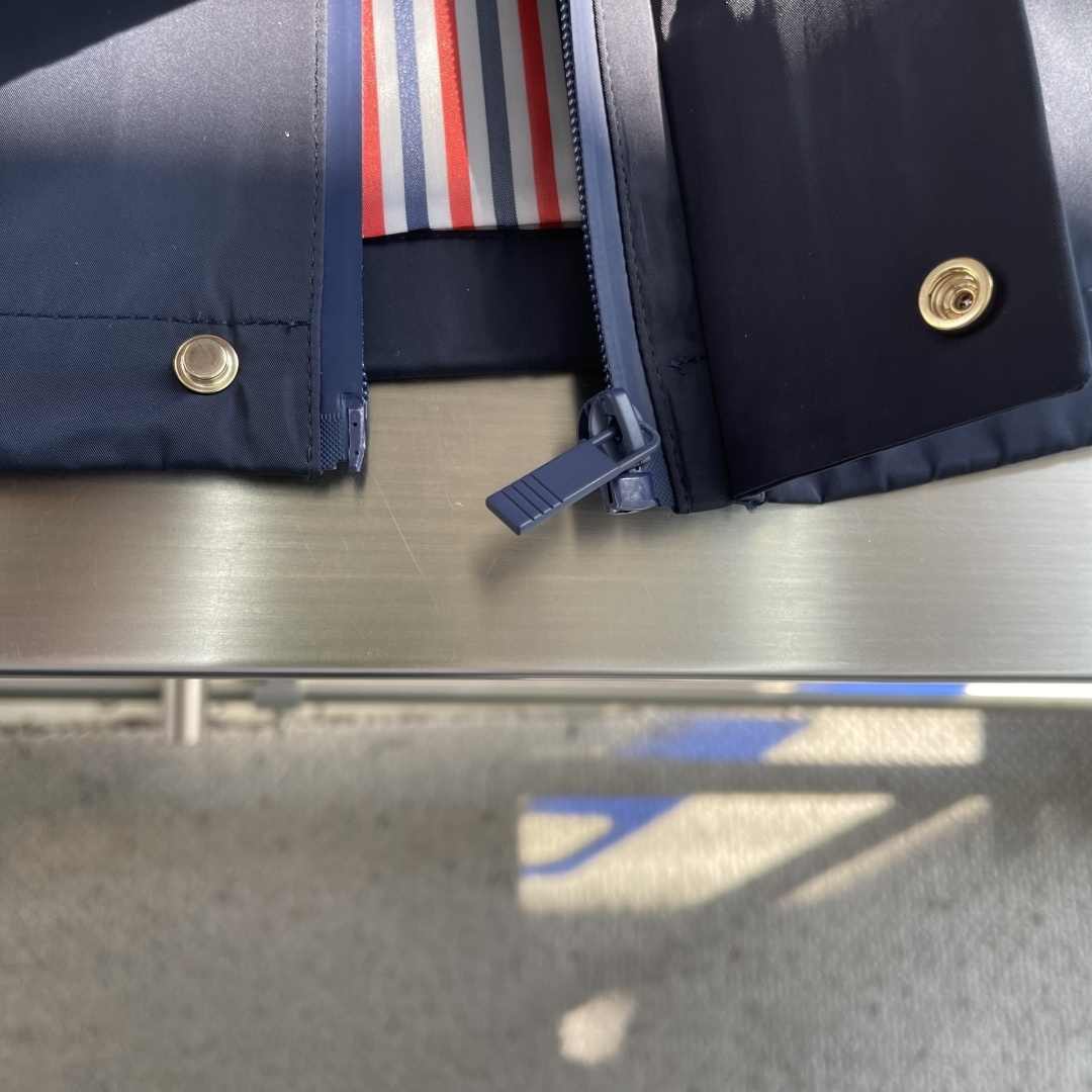 -TB 双袖标连帽冲锋夹克经典纽约标识融合在这件连帽夹克，把高奢细节缝进了通勤松弛感里。胸前户外反光四道