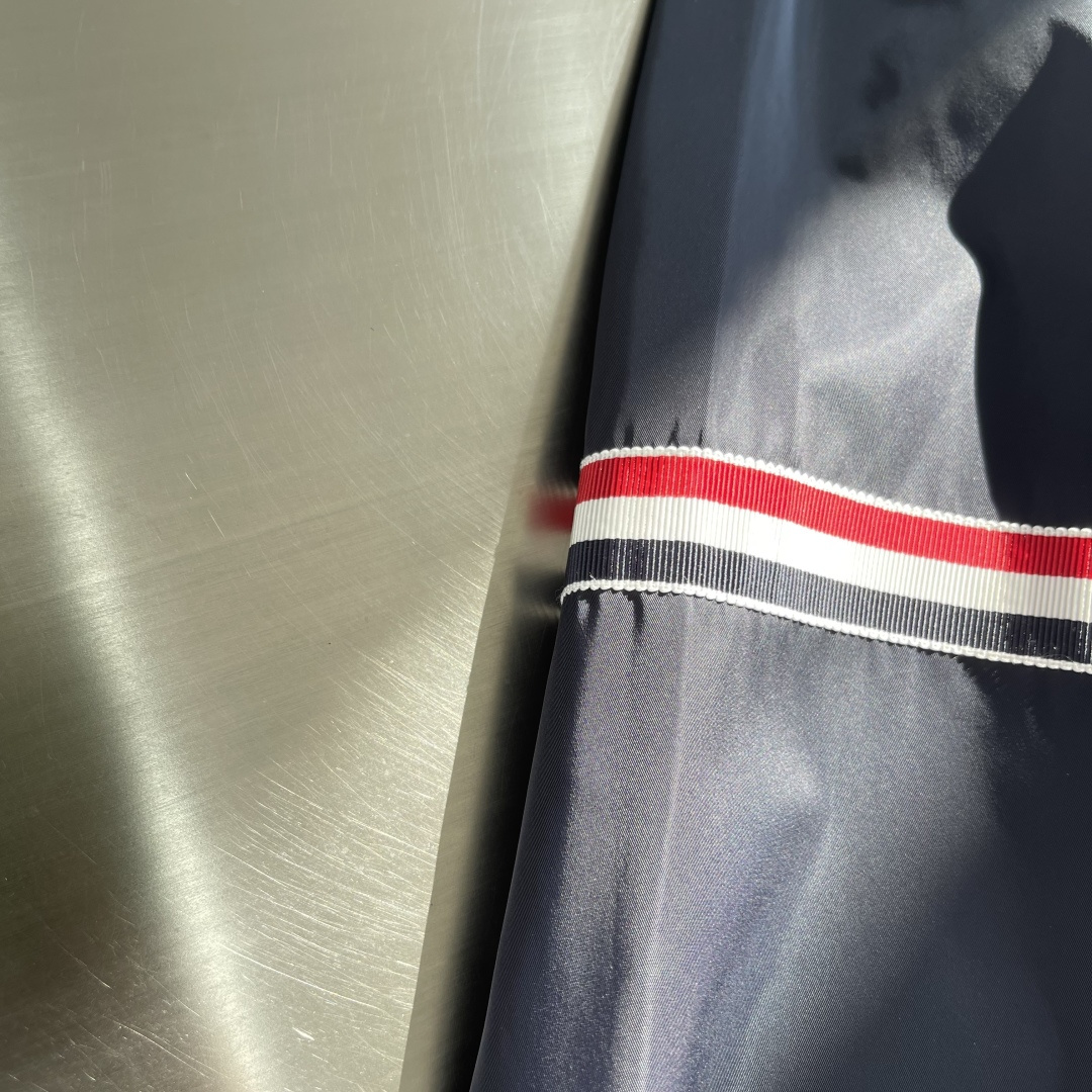 -TB 双袖标连帽冲锋夹克经典纽约标识融合在这件连帽夹克，把高奢细节缝进了通勤松弛感里。胸前户外反光四道