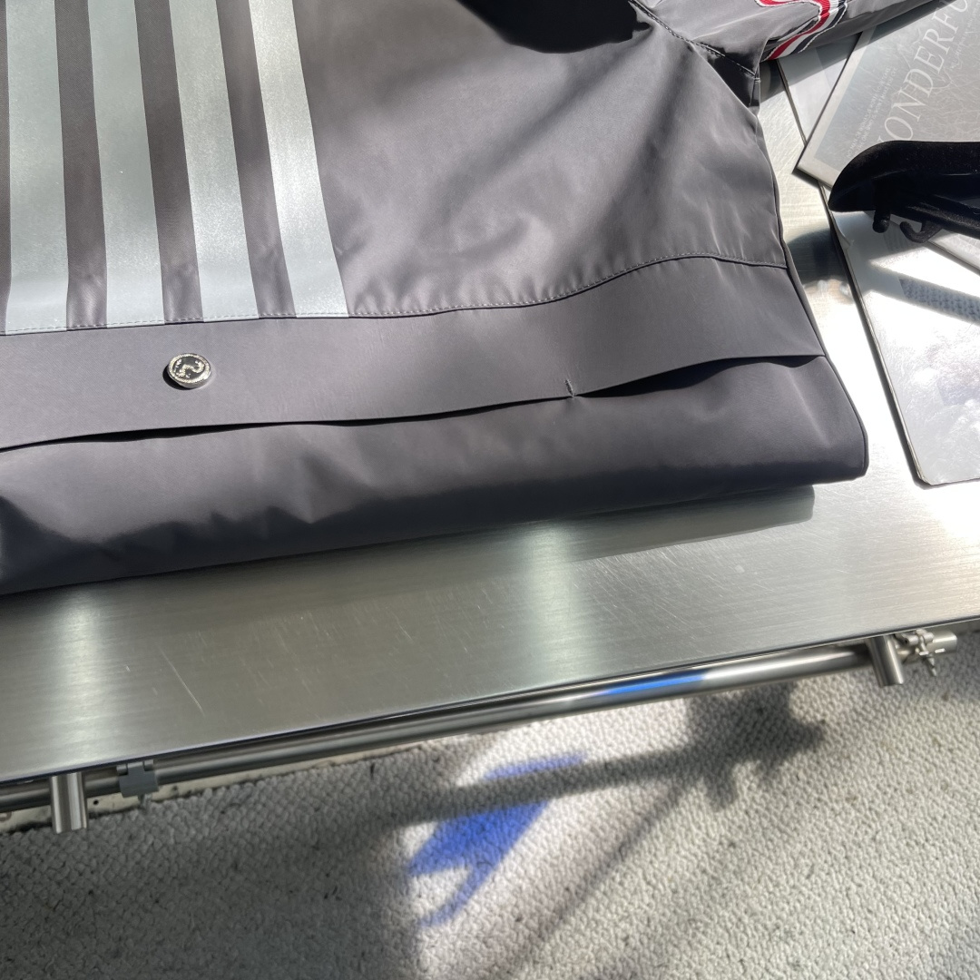 -TB 双袖标连帽冲锋夹克经典纽约标识融合在这件连帽夹克，把高奢细节缝进了通勤松弛感里。胸前户外反光四道