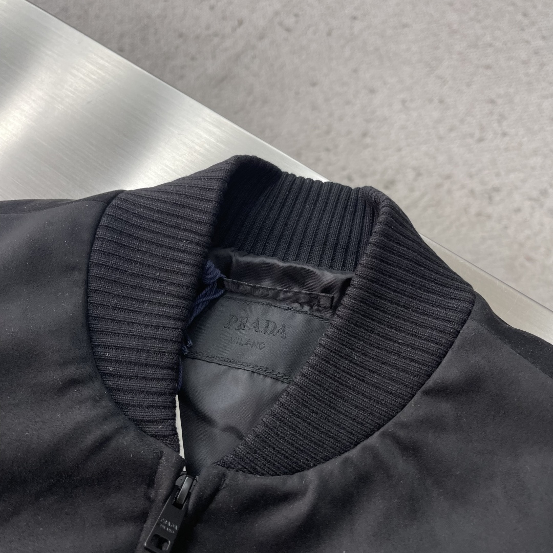 -PRAD 鹿皮绒棒球领夹克，这款夹克采用鹿皮绒面料制作而成，罗纹式领口设计，前胸两大兜袋设计，拉链式开