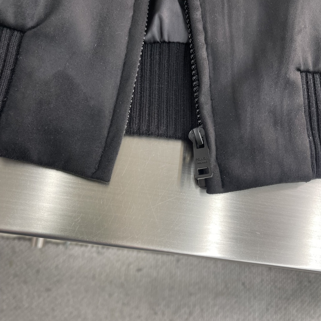 -PRAD 鹿皮绒棒球领夹克，这款夹克采用鹿皮绒面料制作而成，罗纹式领口设计，前胸两大兜袋设计，拉链式开