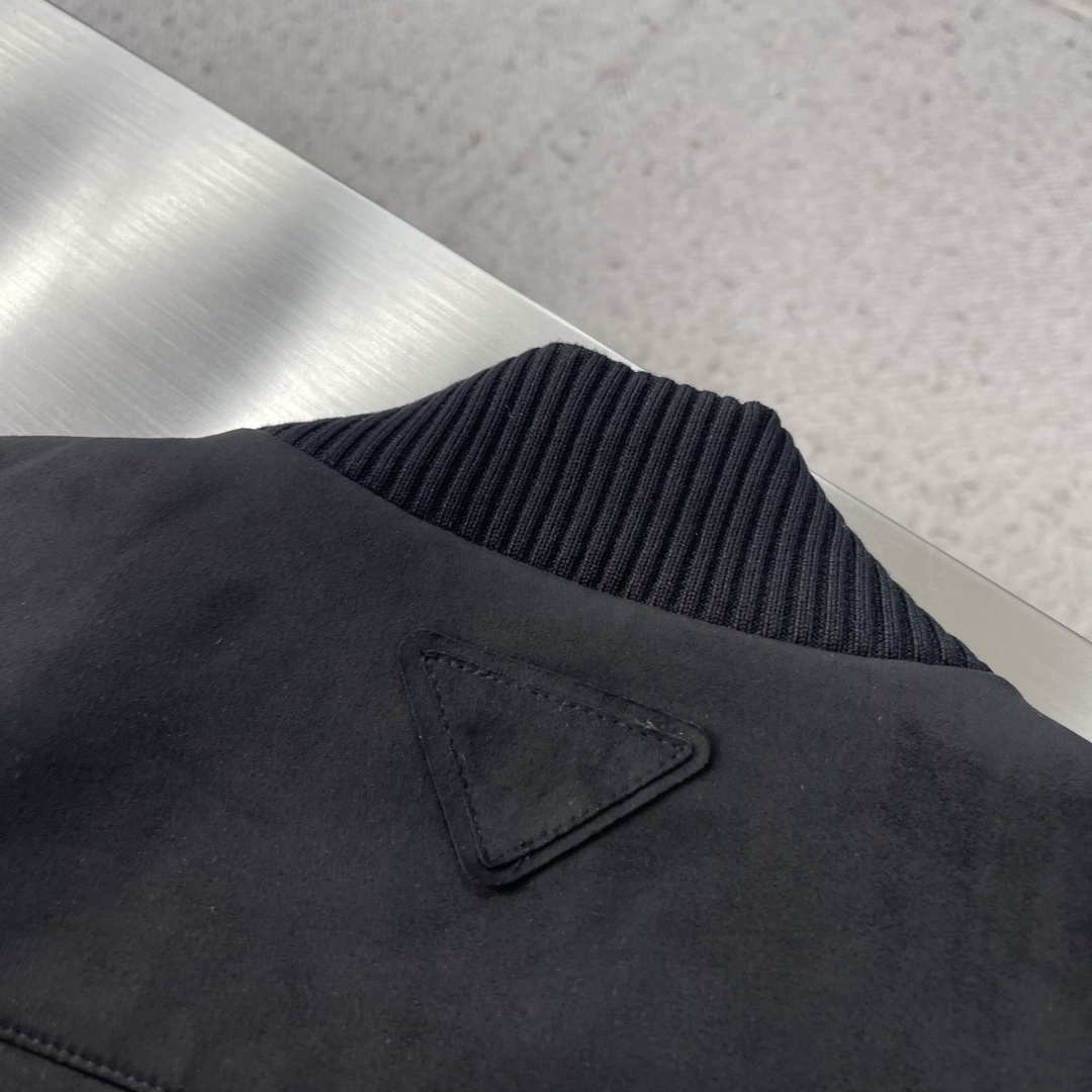 -PRAD 鹿皮绒棒球领夹克，这款夹克采用鹿皮绒面料制作而成，罗纹式领口设计，前胸两大兜袋设计，拉链式开