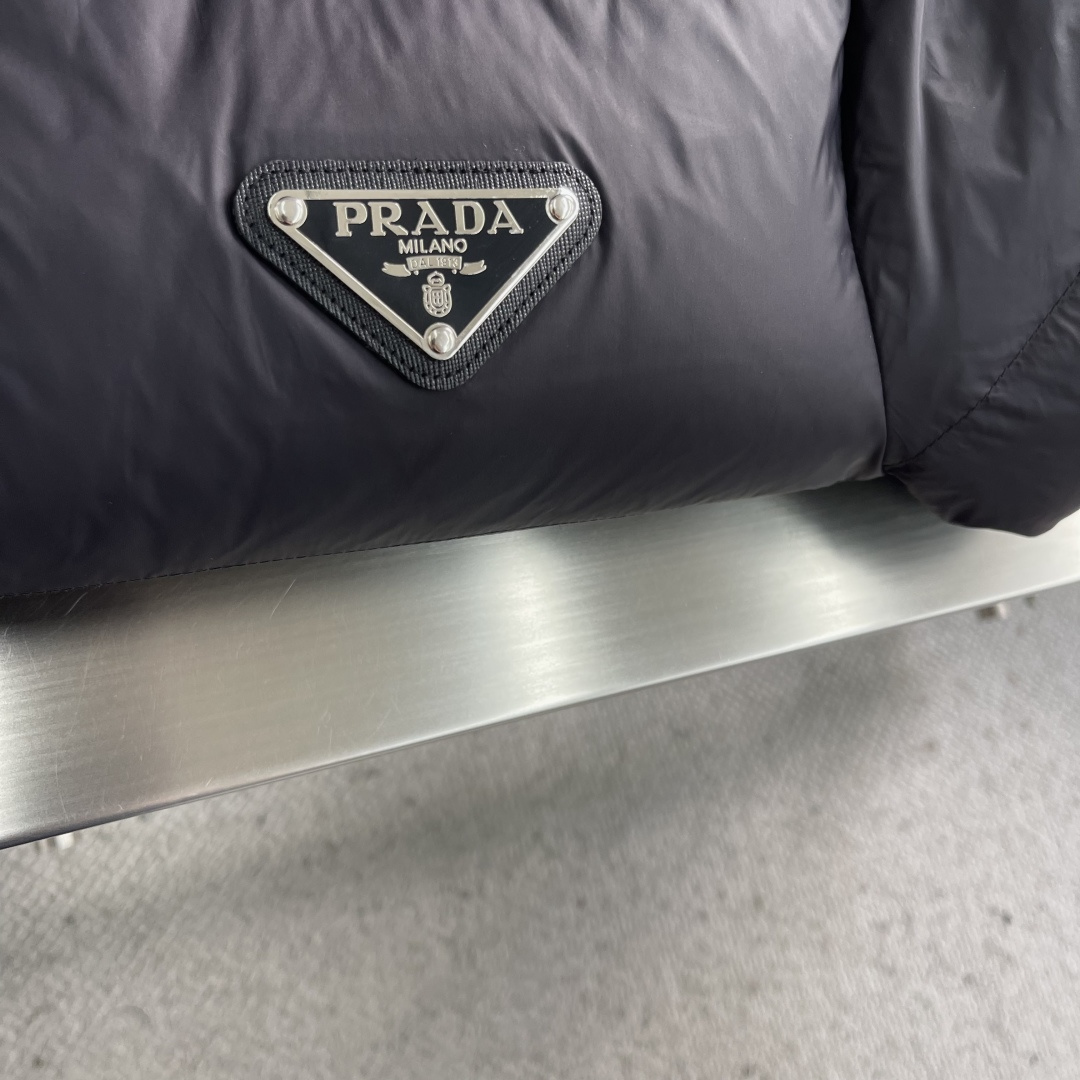 -PRAD 2025秋冬新款连帽羽绒服。黑色经典款，采用优质尼龙面料，轻薄保暖效果出众！简约大气的设计，