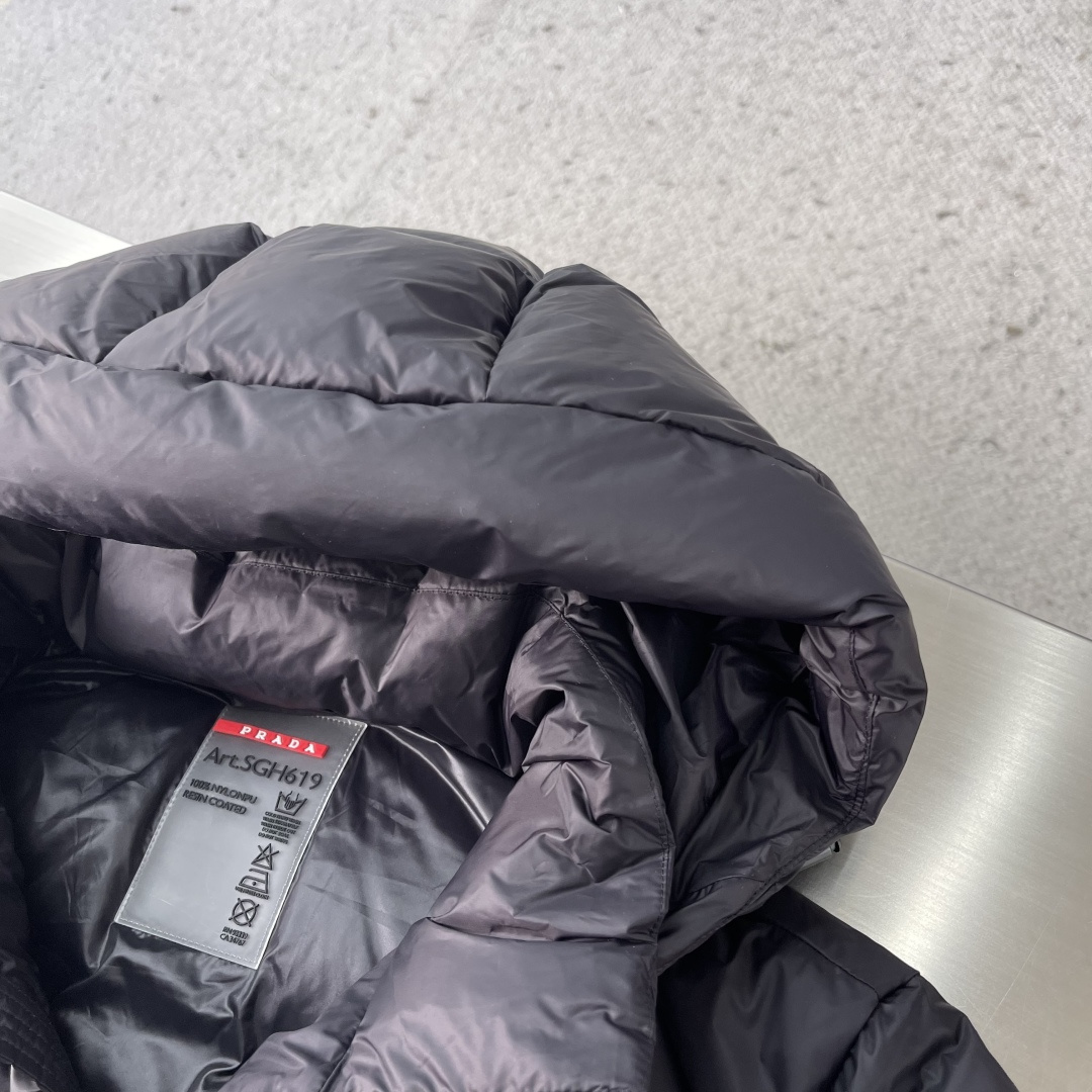 -PRAD 2025秋冬新款连帽羽绒服。黑色经典款，采用优质尼龙面料，轻薄保暖效果出众！简约大气的设计，