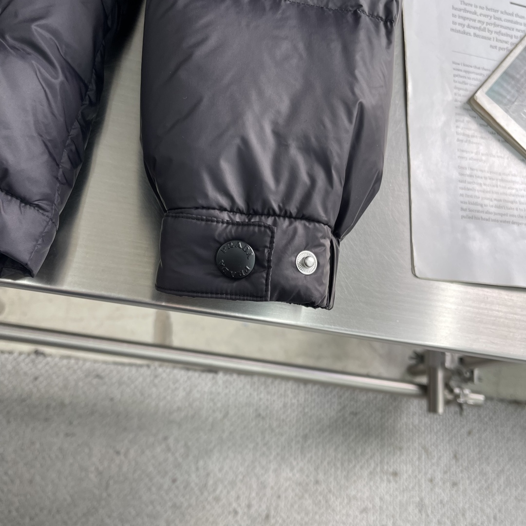 -PRAD 2025秋冬新款连帽羽绒服。黑色经典款，采用优质尼龙面料，轻薄保暖效果出众！简约大气的设计，