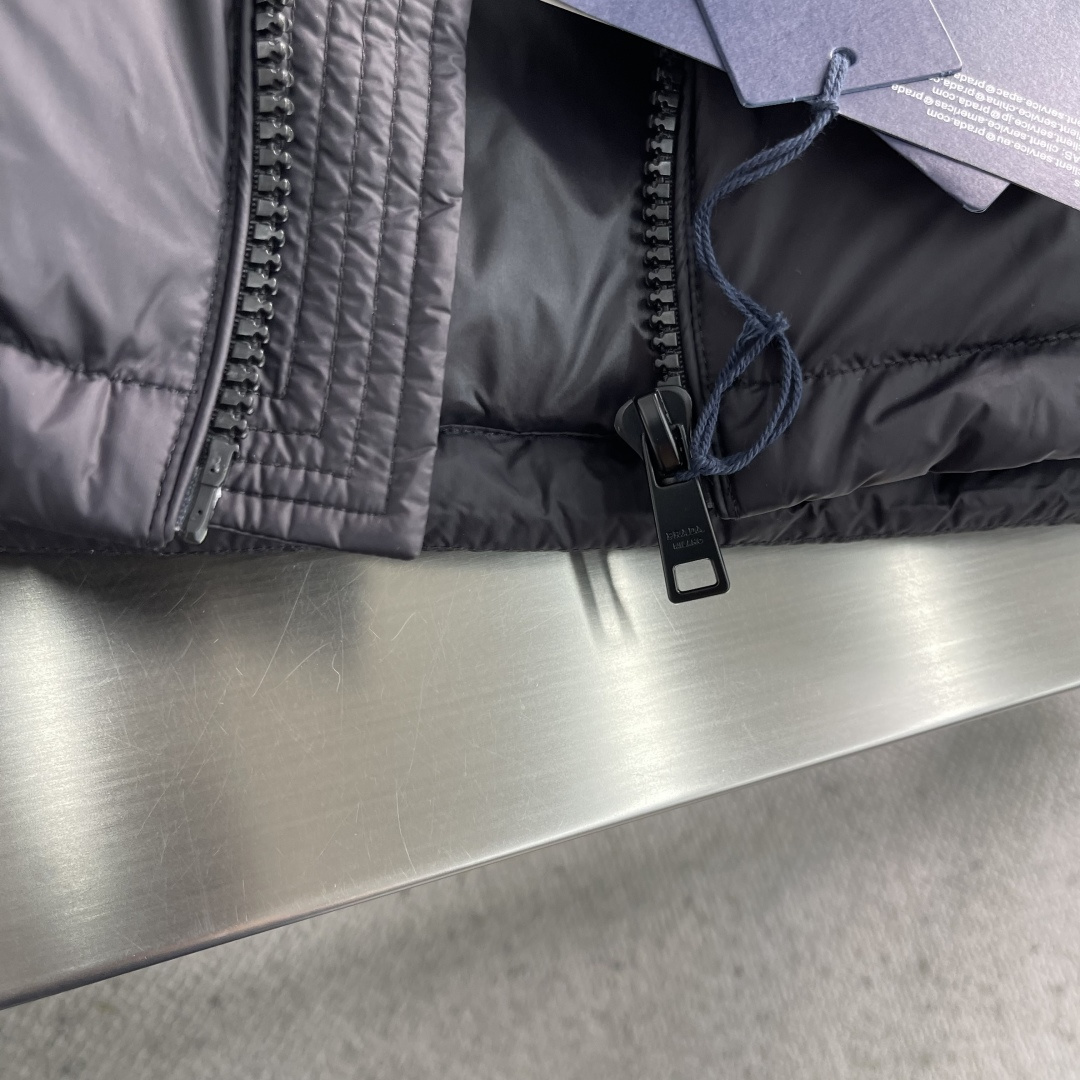 -PRAD 2025秋冬新款连帽羽绒服。黑色经典款，采用优质尼龙面料，轻薄保暖效果出众！简约大气的设计，