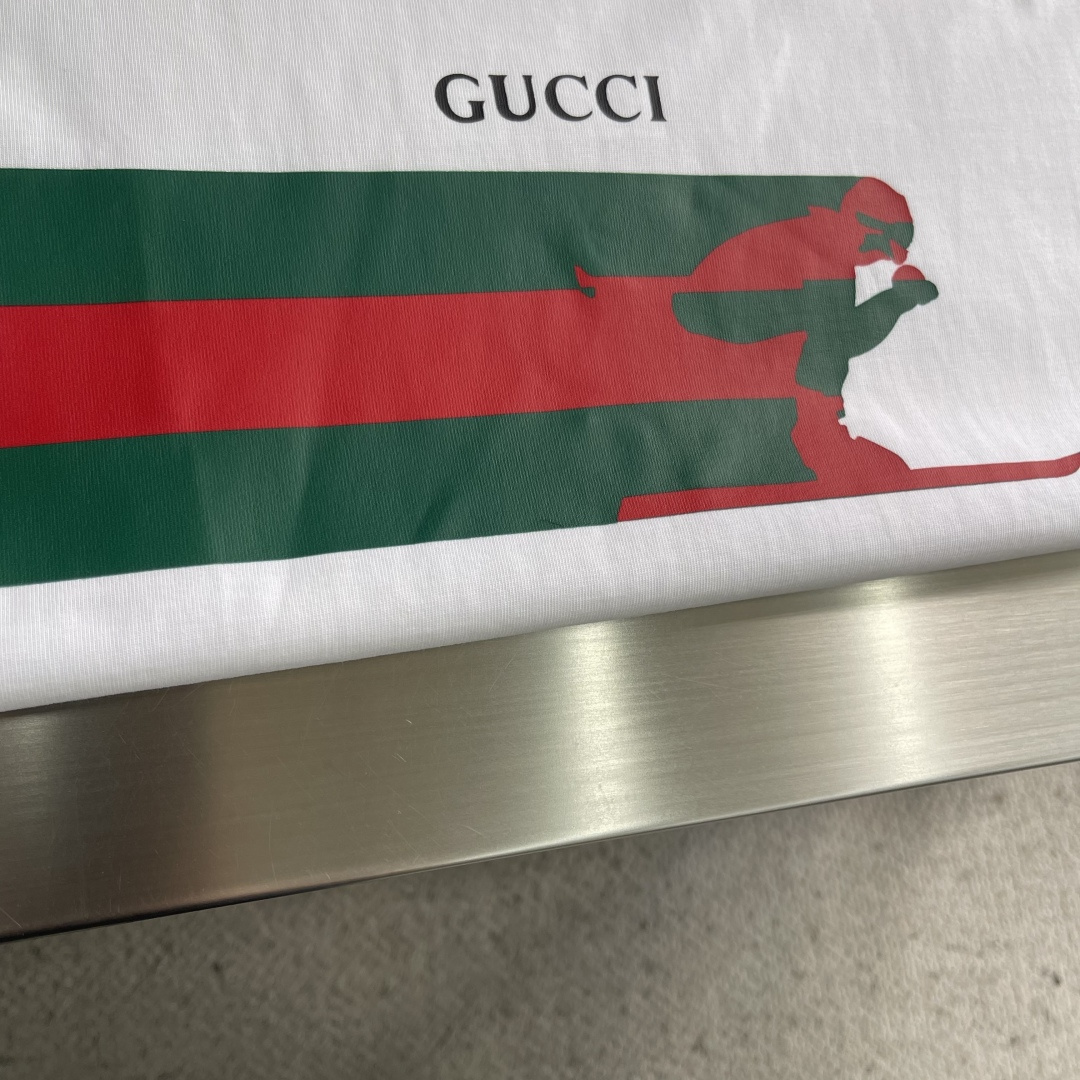 -GUCC 新款新季针织单品，持续匠心演绎品牌元素。这款T恤以白色针织棉匠心打造，缀饰Gucc滑雪者织带