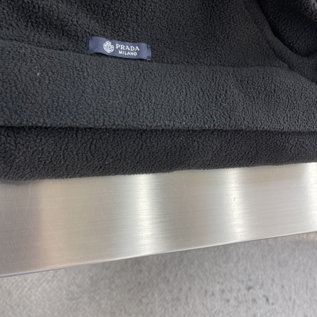 -PRAD 26ss摇粒绒夹克主要原料为聚酯纤维混纺羊毛原料经过清洗和预处理，以去除杂质。纱线通过织机织