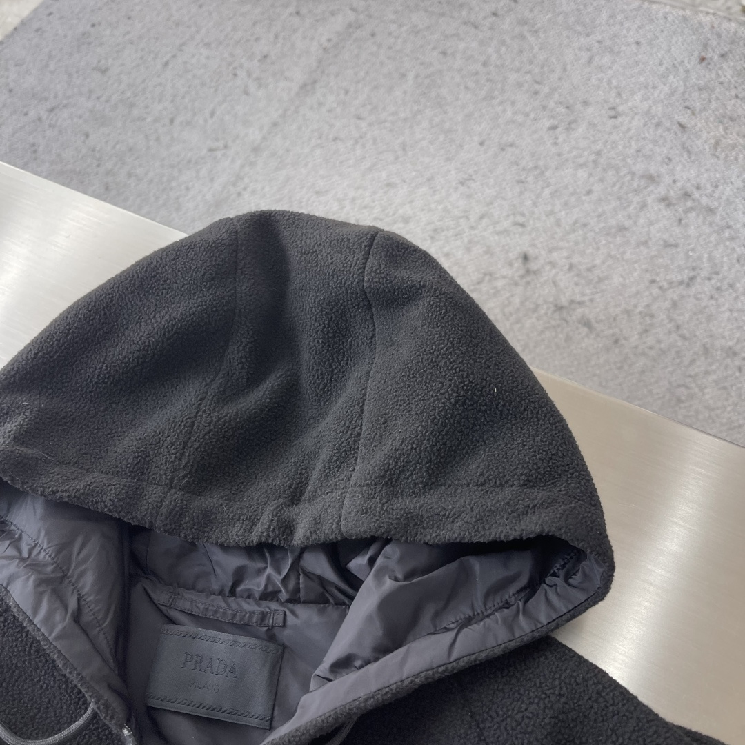 -PRAD 26ss摇粒绒夹克主要原料为聚酯纤维混纺羊毛原料经过清洗和预处理，以去除杂质。纱线通过织机织