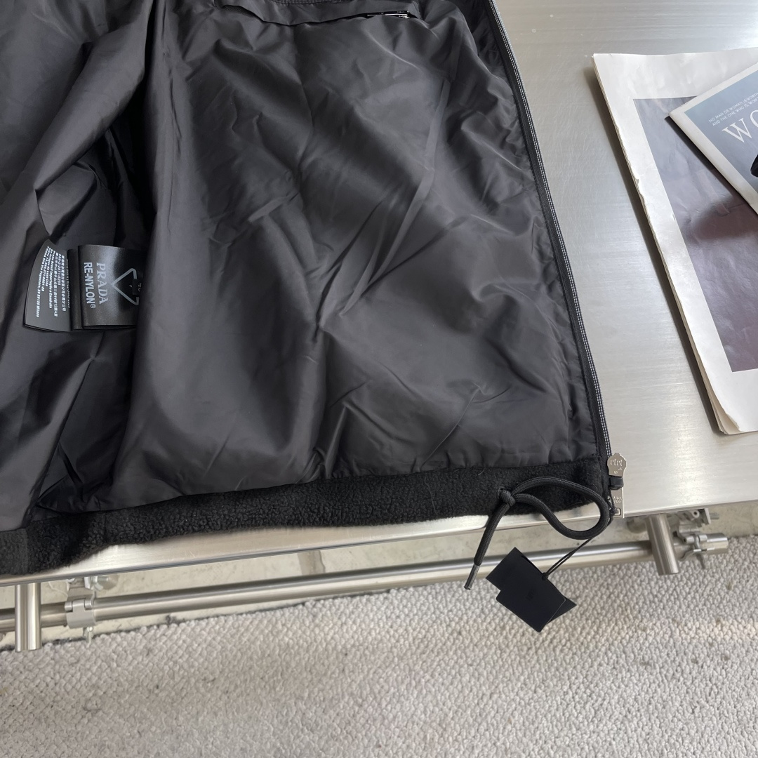 -PRAD 26ss摇粒绒夹克主要原料为聚酯纤维混纺羊毛原料经过清洗和预处理，以去除杂质。纱线通过织机织