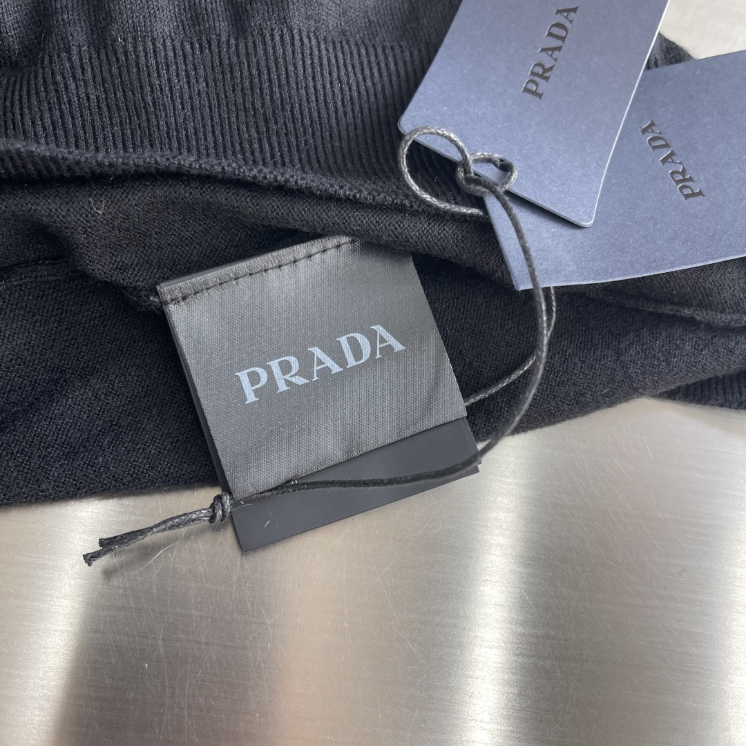-PRAD 26SS精纺羊毛长袖采用精纺羊毛材质，这种材质具有以下特点：柔软轻盈：精纺羊毛纤维细腻，使得