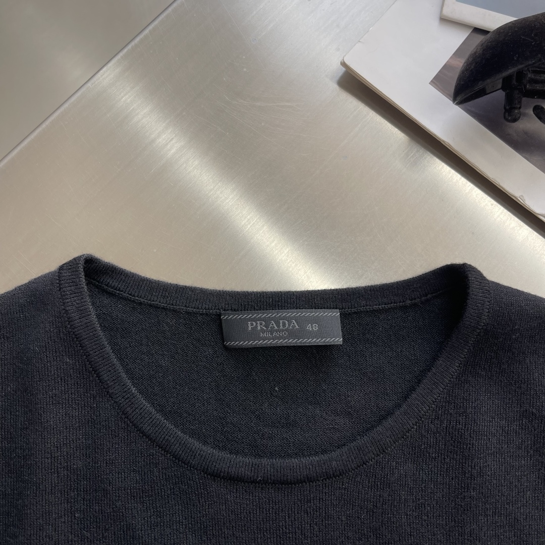 -PRAD 26SS精纺羊毛长袖采用精纺羊毛材质，这种材质具有以下特点：柔软轻盈：精纺羊毛纤维细腻，使得