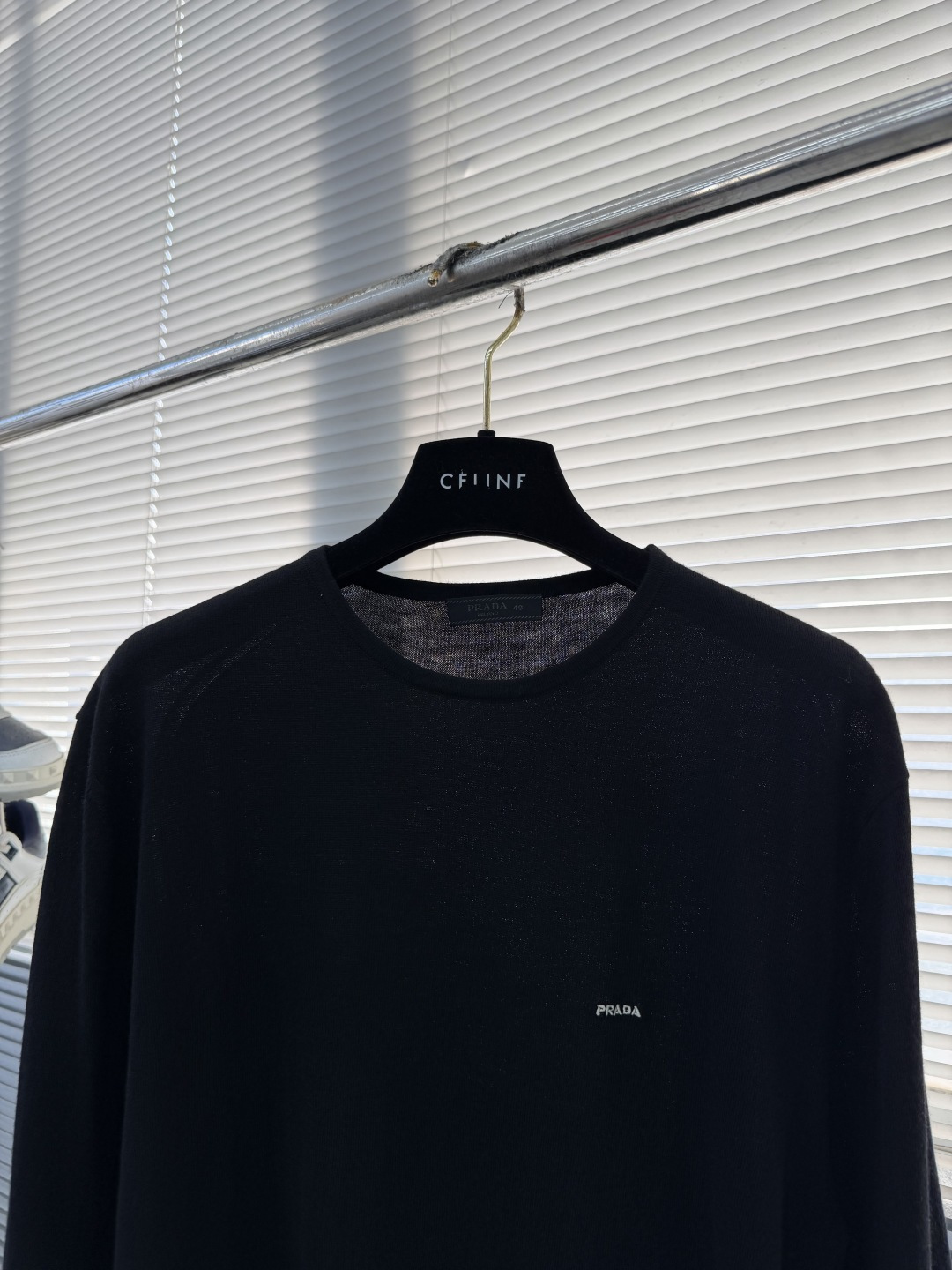 -PRAD 26SS精纺羊毛长袖采用精纺羊毛材质，这种材质具有以下特点：柔软轻盈：精纺羊毛纤维细腻，使得