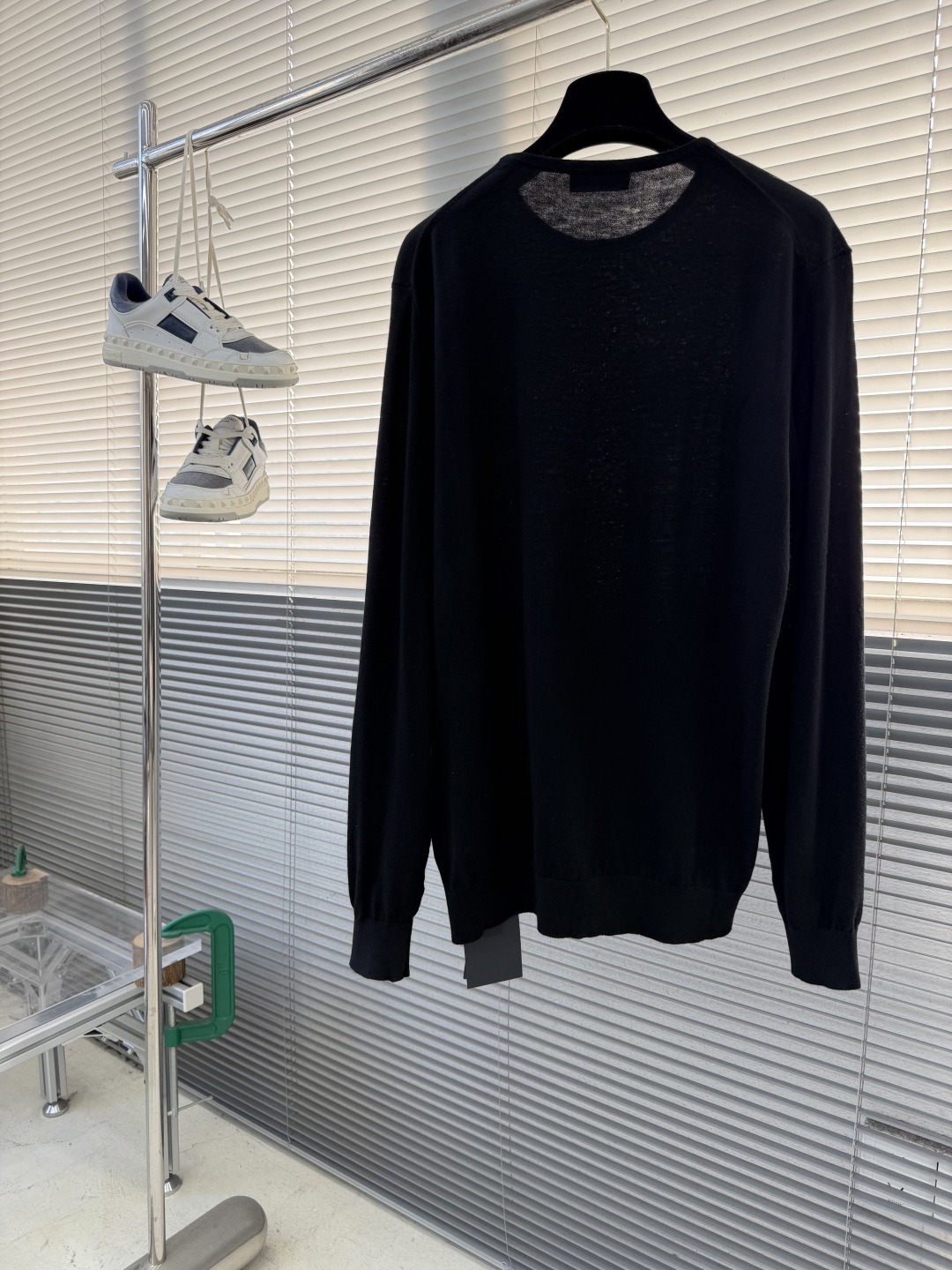 -PRAD 26SS精纺羊毛长袖采用精纺羊毛材质，这种材质具有以下特点：柔软轻盈：精纺羊毛纤维细腻，使得