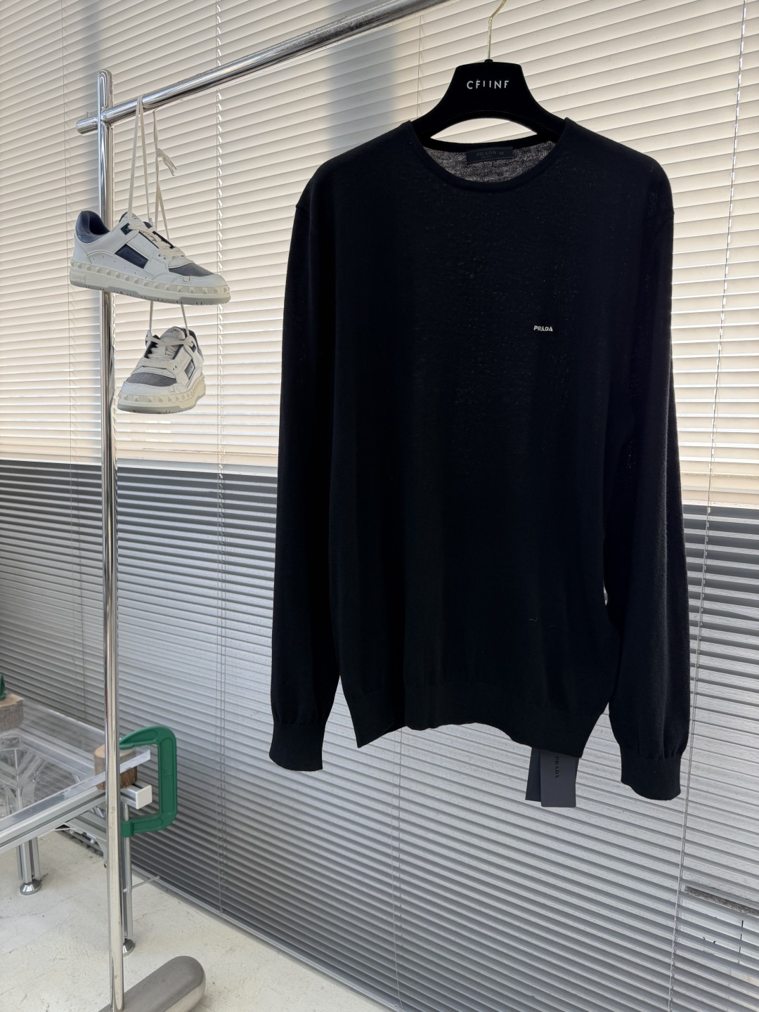 -PRAD 26SS精纺羊毛长袖采用精纺羊毛材质，这种材质具有以下特点：柔软轻盈：精纺羊毛纤维细腻，使得