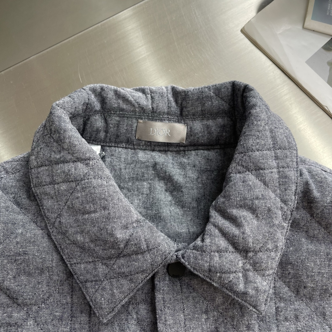 -Dio 饰刺绣章衬衫式外套选用100%棉打造而成，面料厚实，触摸起来柔软平整，能留存更多静止空气，有效